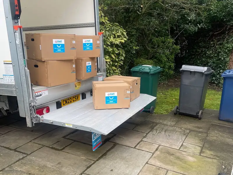Packed MET Removals boxes on the tail lift of a removals van, packing services in Walthamstow