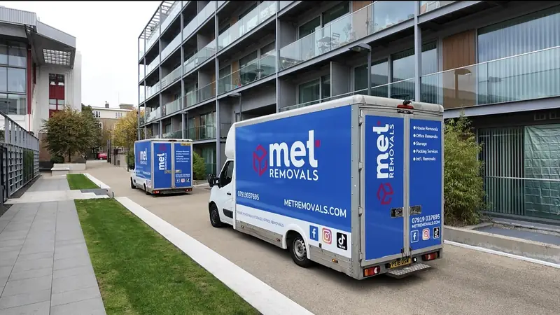Two MET Removals vans parked outside a modern office building, office removals in Chigwell